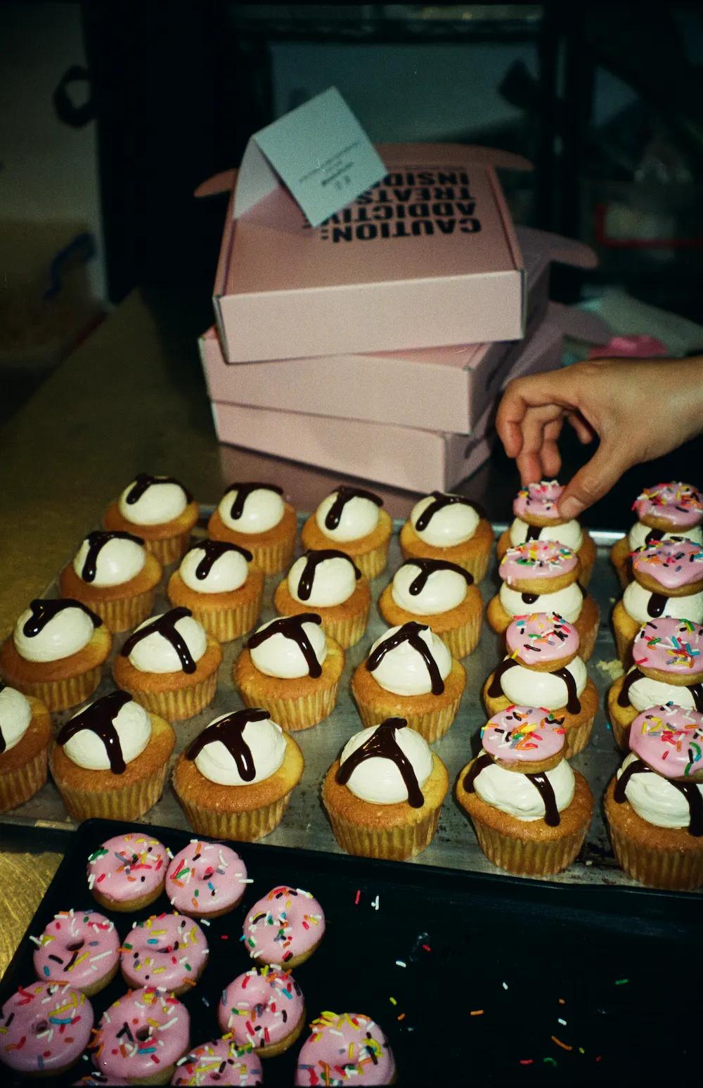 trays of fresh cupcakes and donuts
